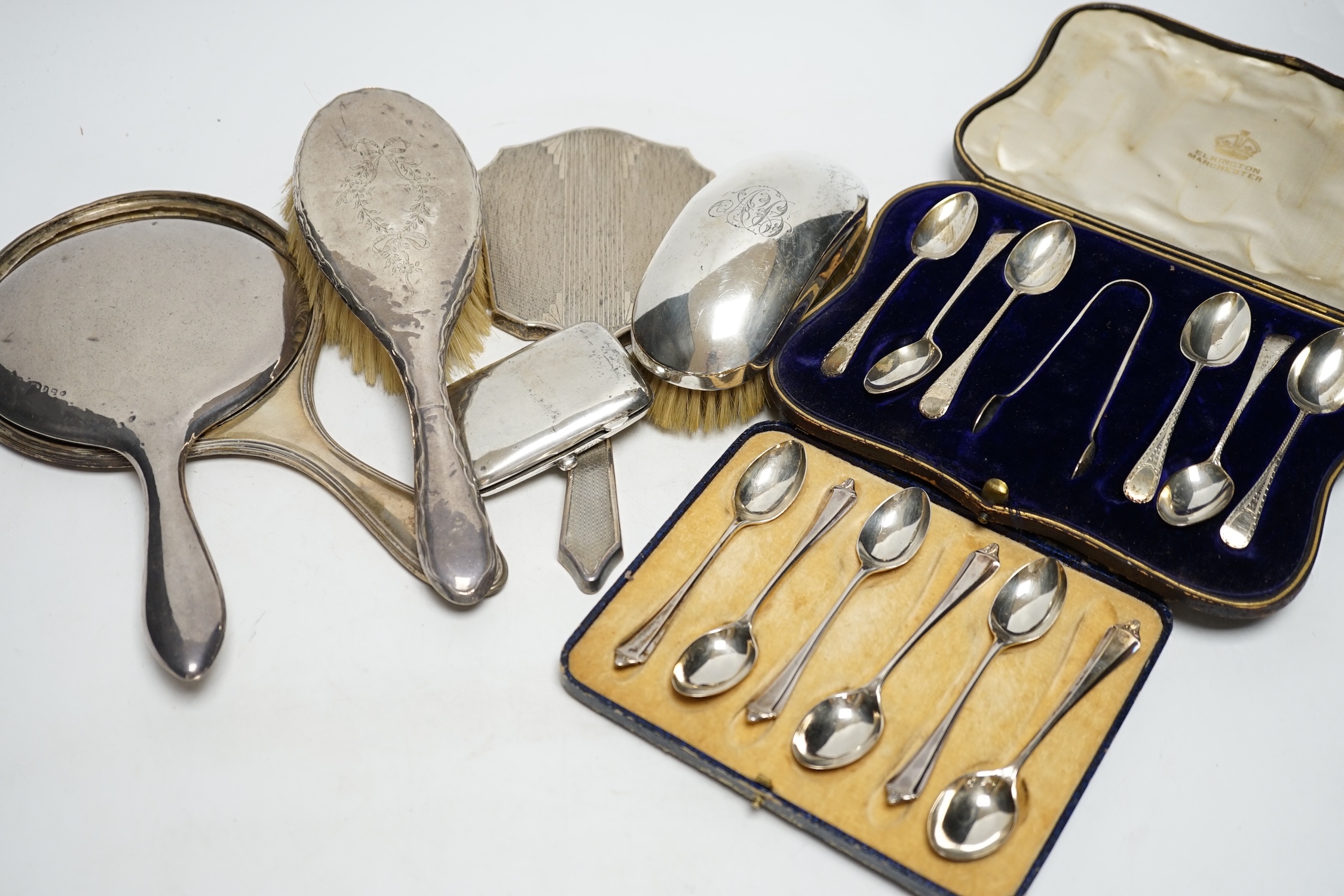 Two cased sets of six silver teaspoons, assorted silver mounted brushes and damaged mirror and a silver cigarette case.